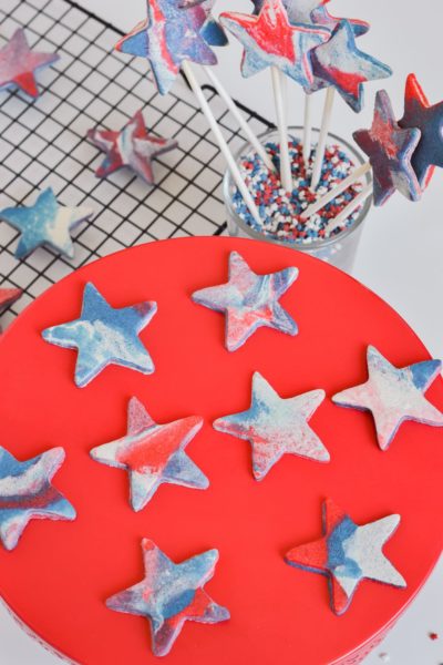 red white blue marble cookies on red cake stand and cooling tracy