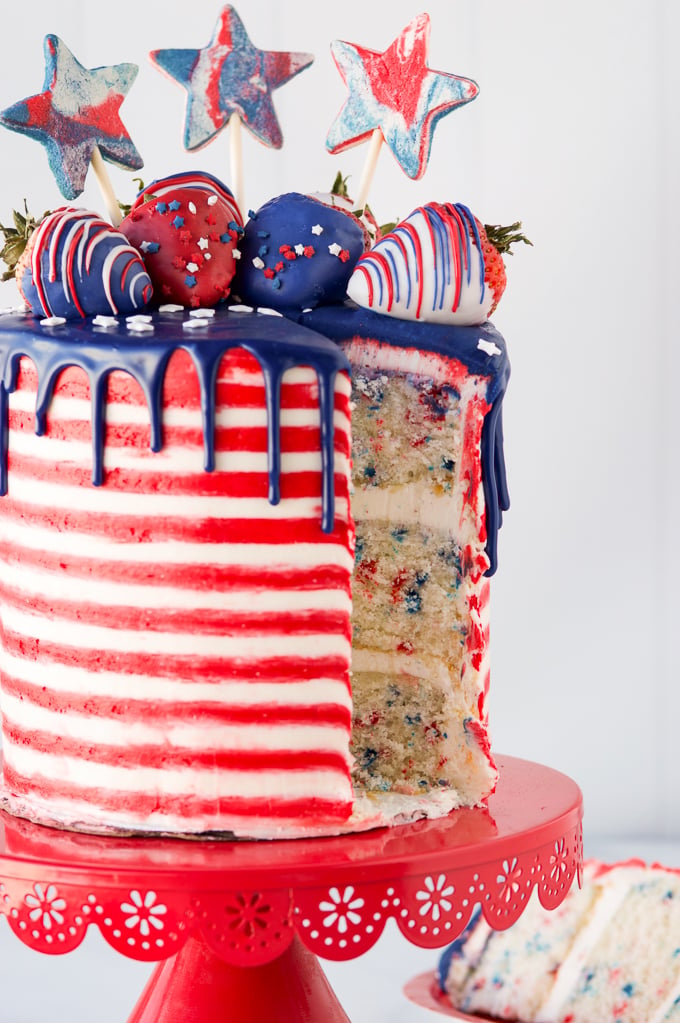 4th of july cake on red cake stand with cake slice