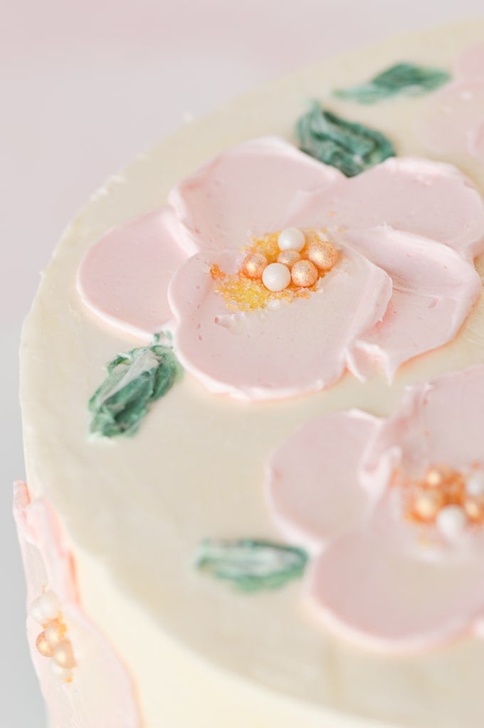 pink flowers painted in buttercream on cake up close