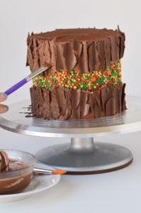 painting chocolate onto a cake to look like bark