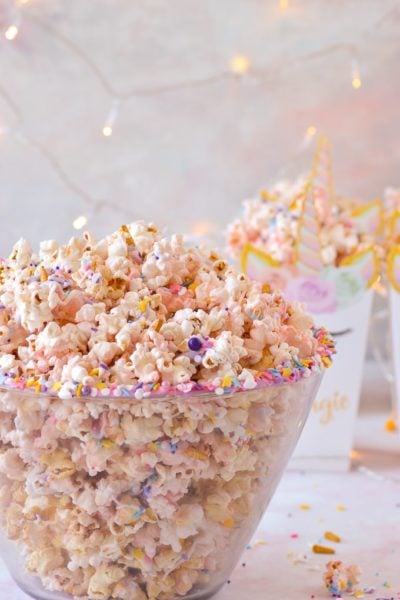 unicorn popcorn in bowl with boxes of unicorn popcorn