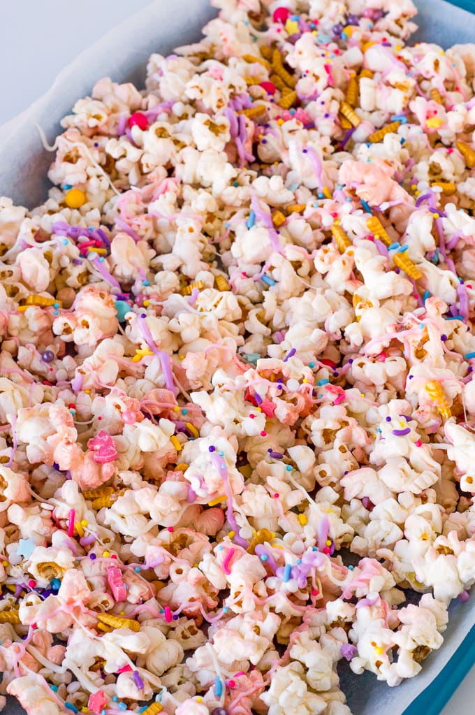 popcorn covered in melted pink and purple melted chocolate and sprinkles