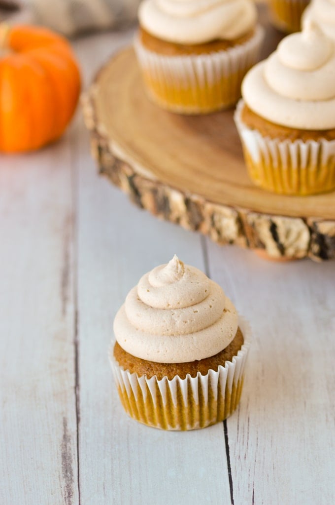 pumpkin cupcake frosted with cupcakes in background
