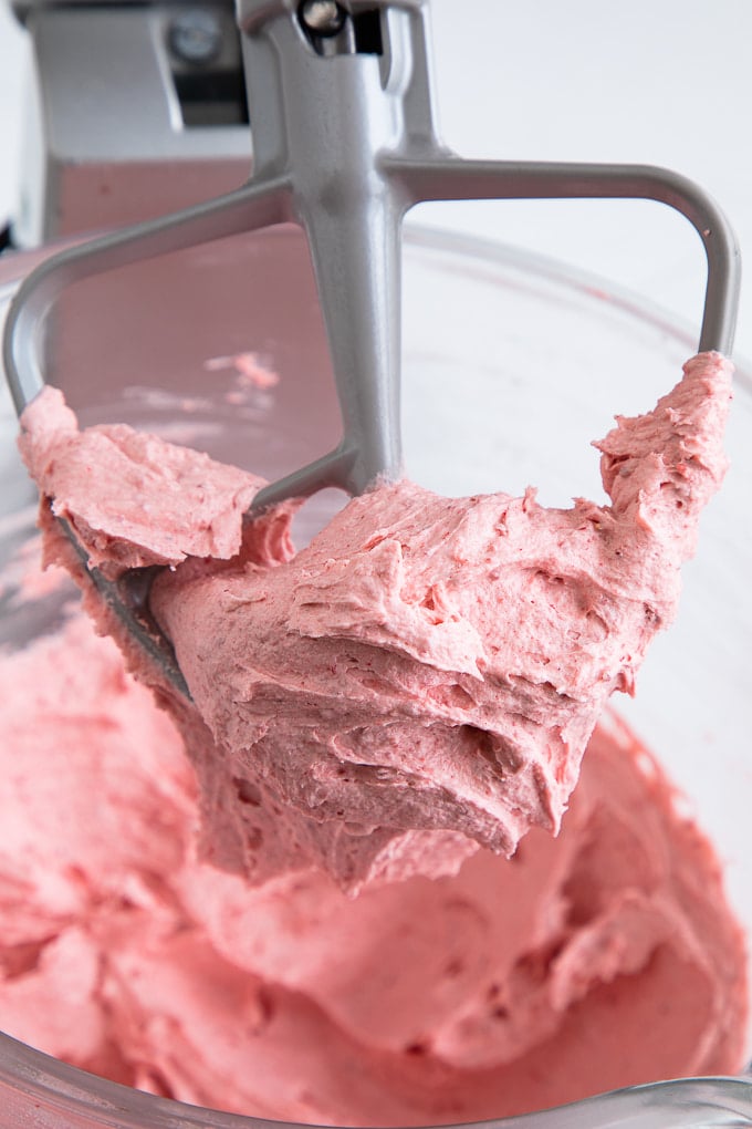 strawberry buttercream frosting on beater up close