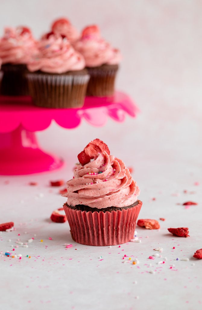 strawberry frosting on chocolate cupcake with sprinkles 