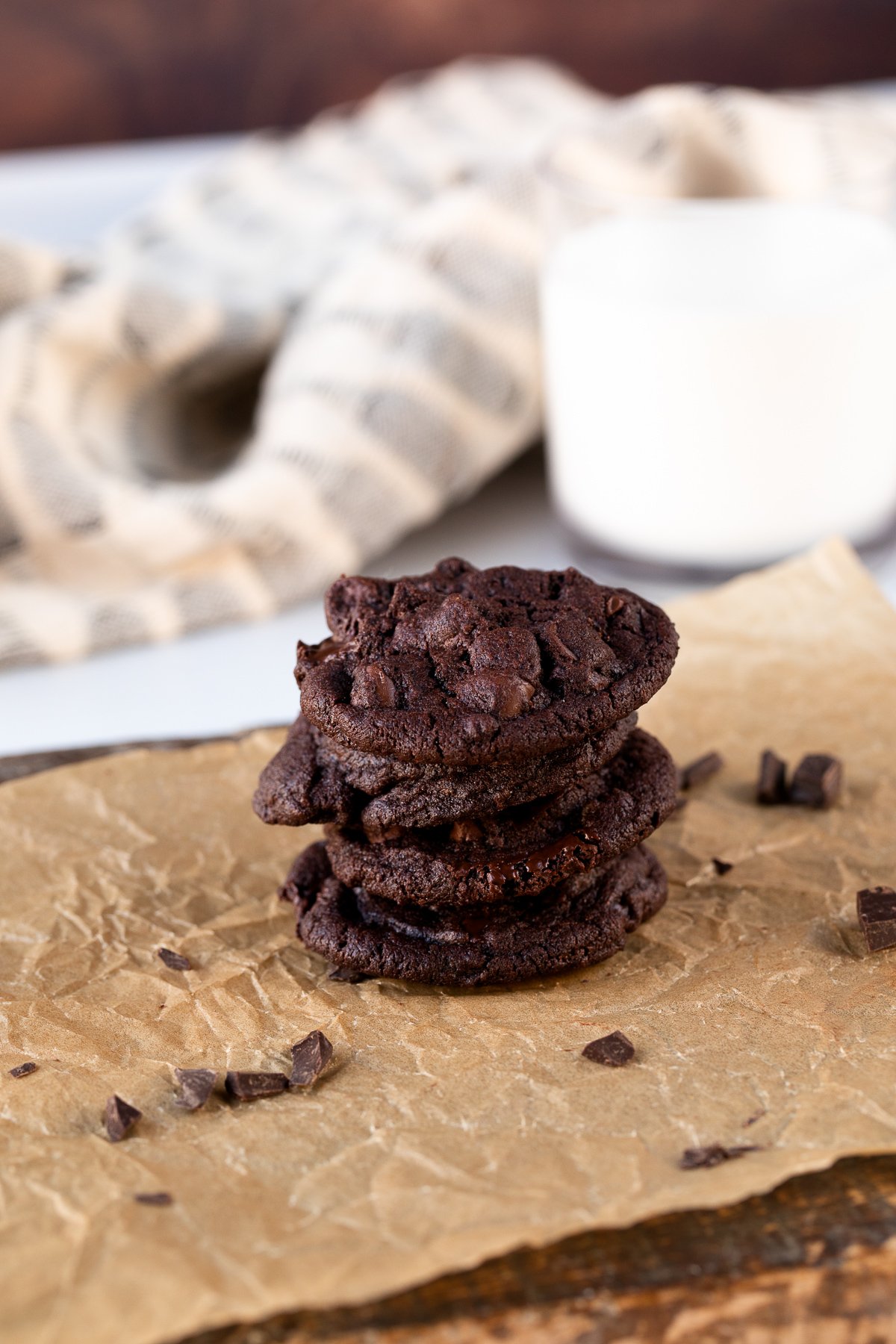 stack of double chocolate chip cookies with glass of milk
