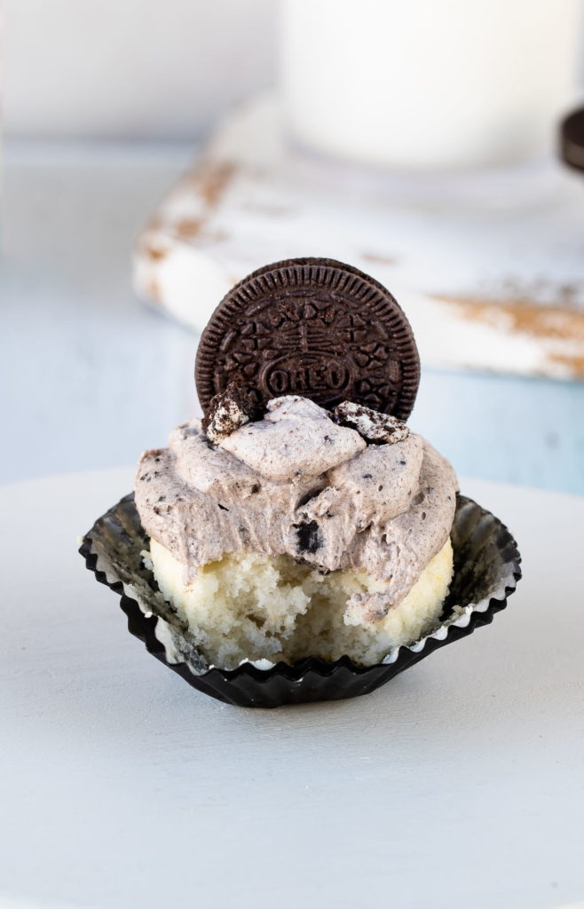 up close of oreo frosting on a cupcake with a bite taken out