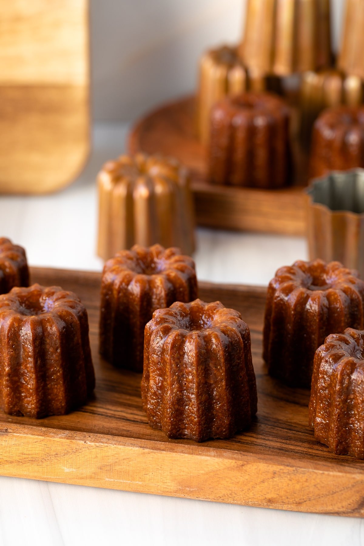 french caneles on wood serving tray