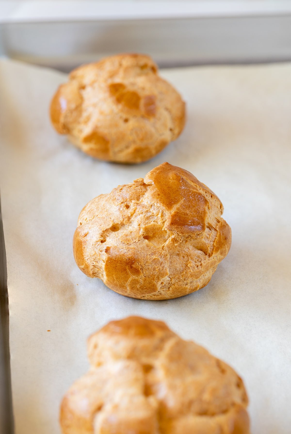 baked cream puff on parchment up close.