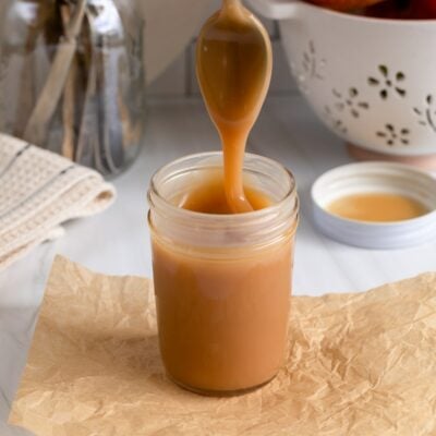 caramel sauce in jar with spoon.