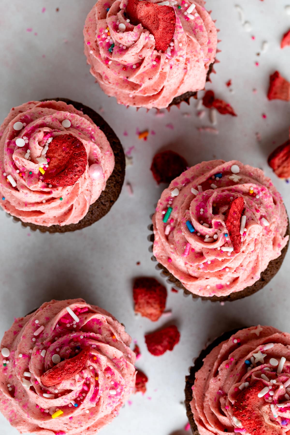 strawberry frosting on cupcakes with sprinkles.