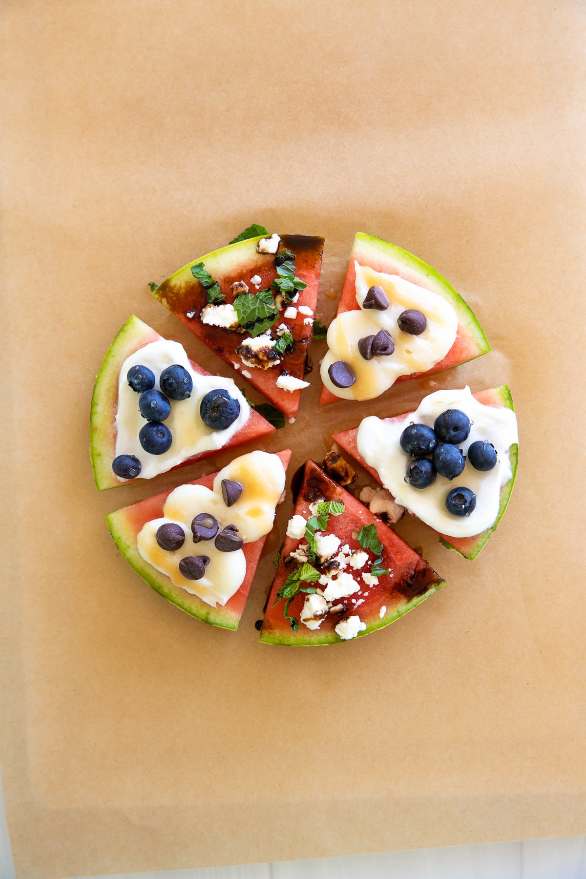 watermelon pizza with a variety of toppings cut into slices.