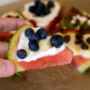holding a piece of watermelon pizza up close