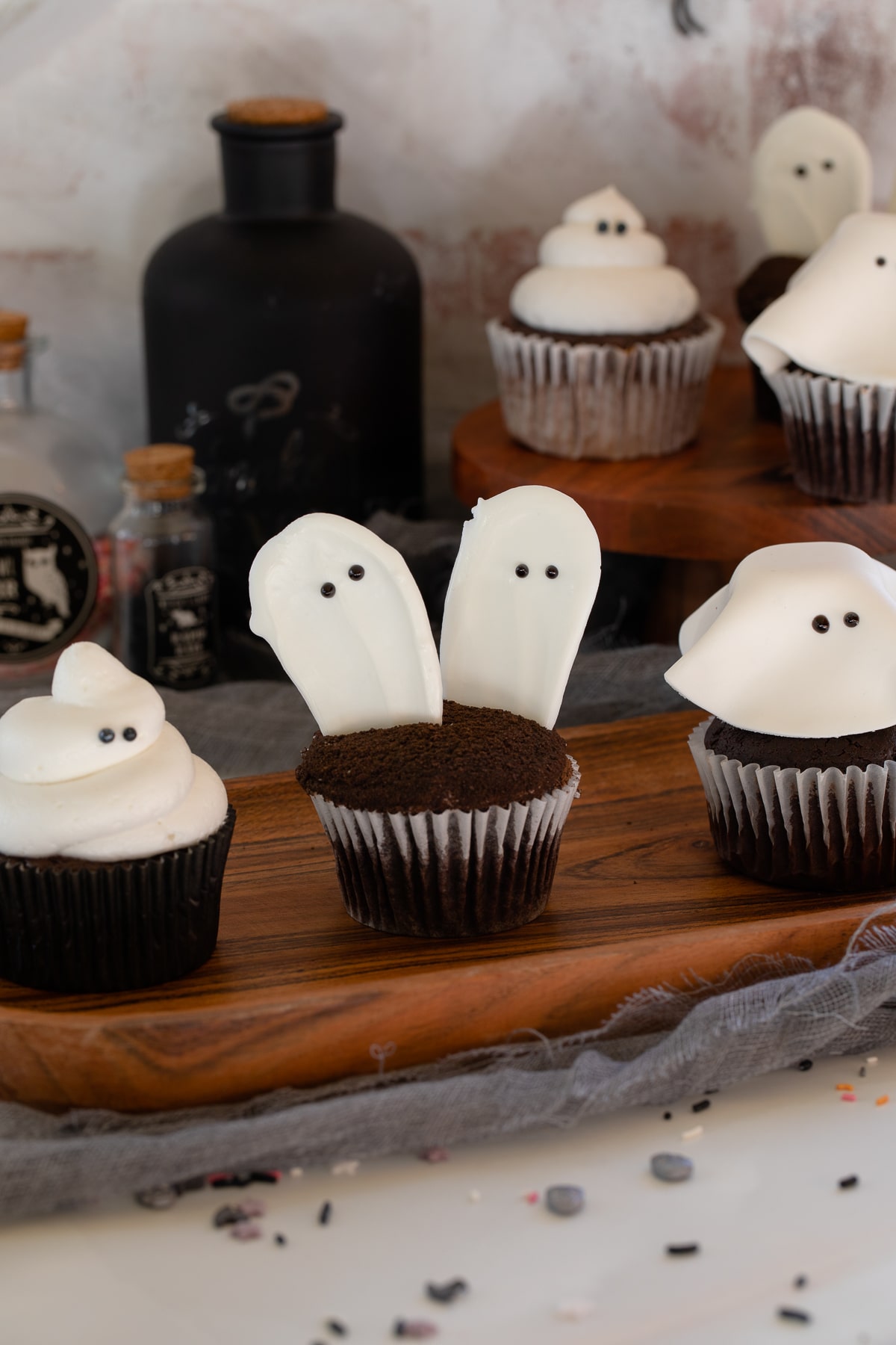 ghost cupcakes on wooden platte up close.