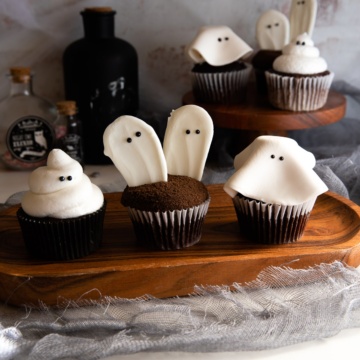 ghost cupcakes on wooden platter.