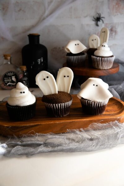 ghost cupcakes on wooden platter.