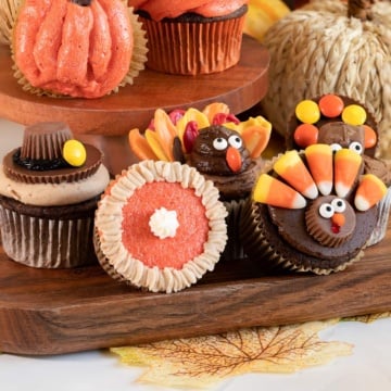 decorated thanksgiving cupcakes on wooden tray.