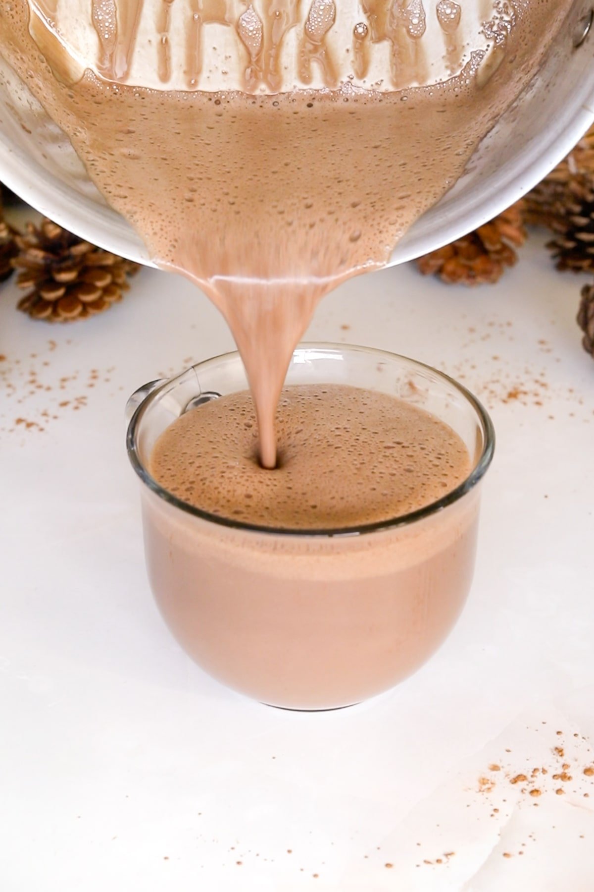 pouring hot chocolate into mug.