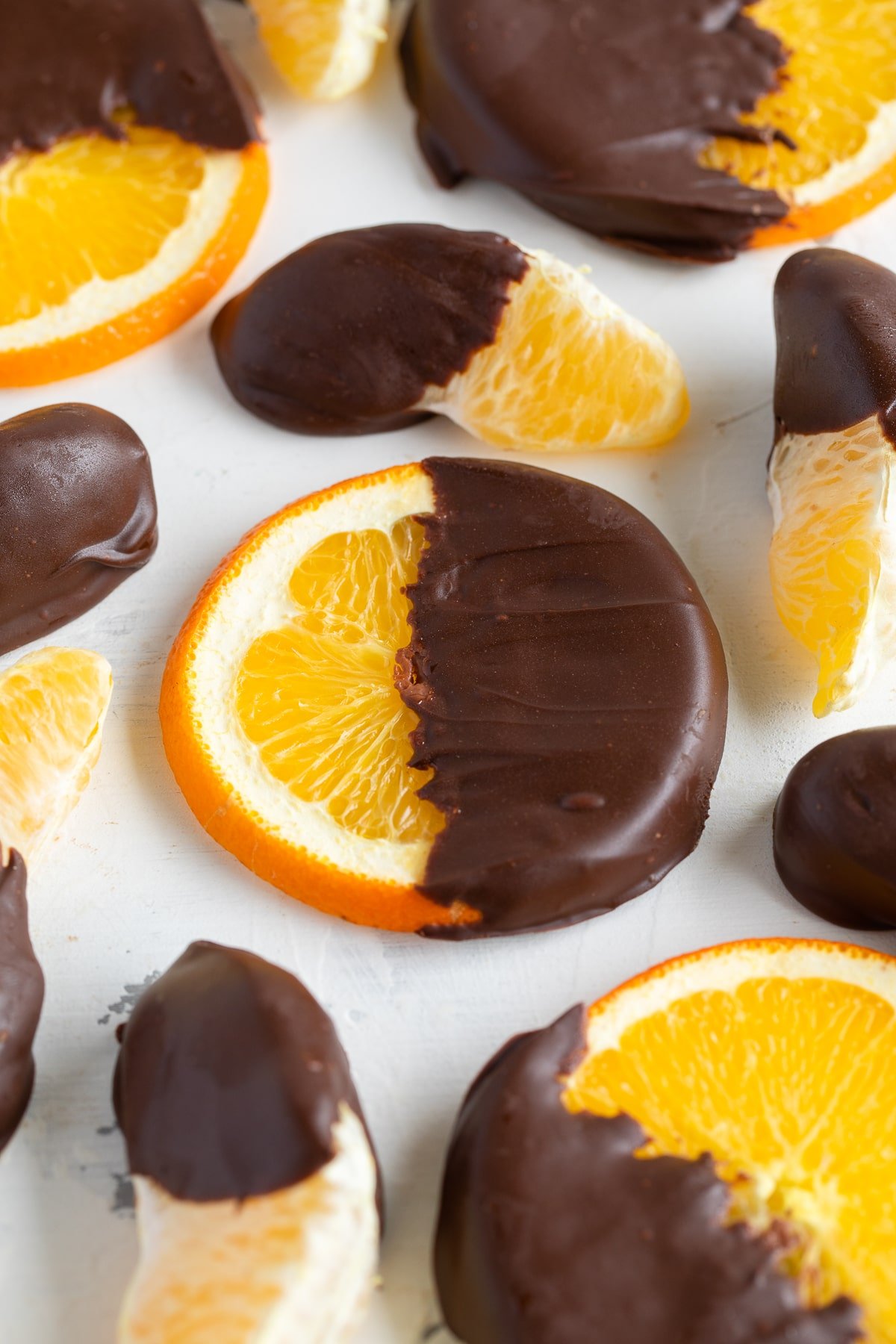chocolate covered orange slices on cutting board.