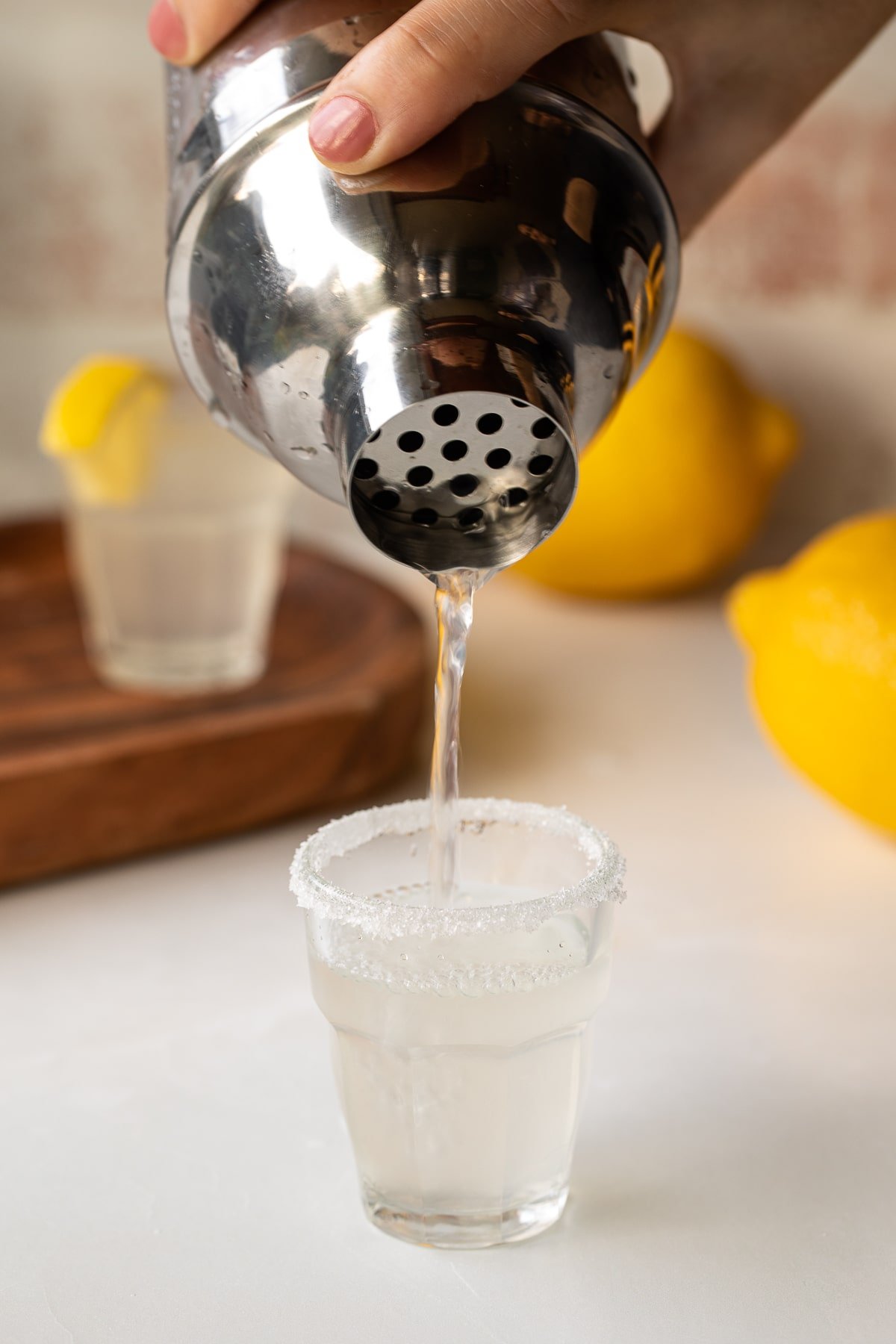 pouring lemon drop shot into shot glass.