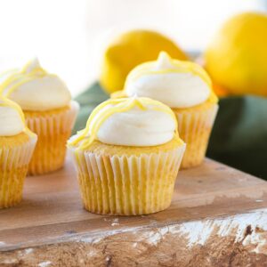 lemon buttercream frosting on yellow cupcake with lemon curd drizzle.