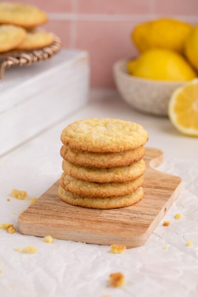 soft lemon sugar cookies stacked on wood board.