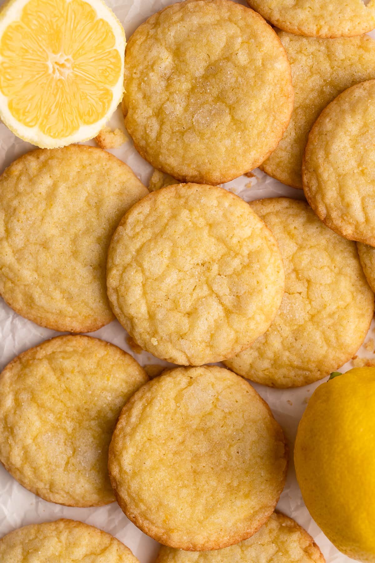 lemon cookies on parchment with lemons.