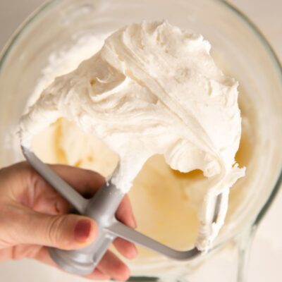 holding a beater of champagne buttercream.