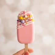 holding up pink cakesicle.