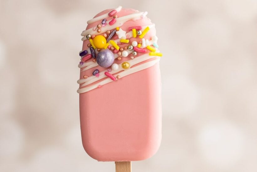 holding up pink cakesicle.