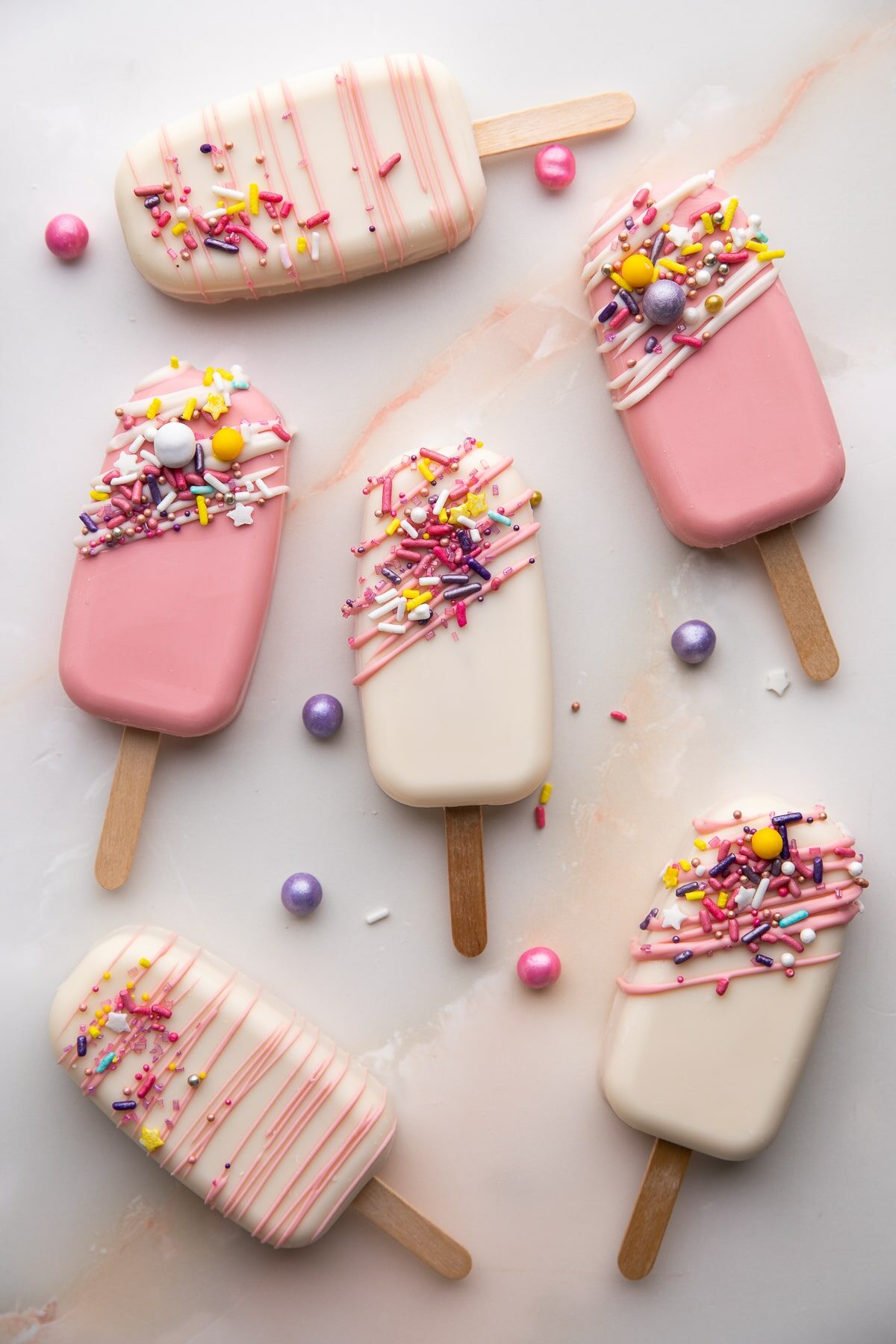 cakesicles from top view on table with sprinkles.