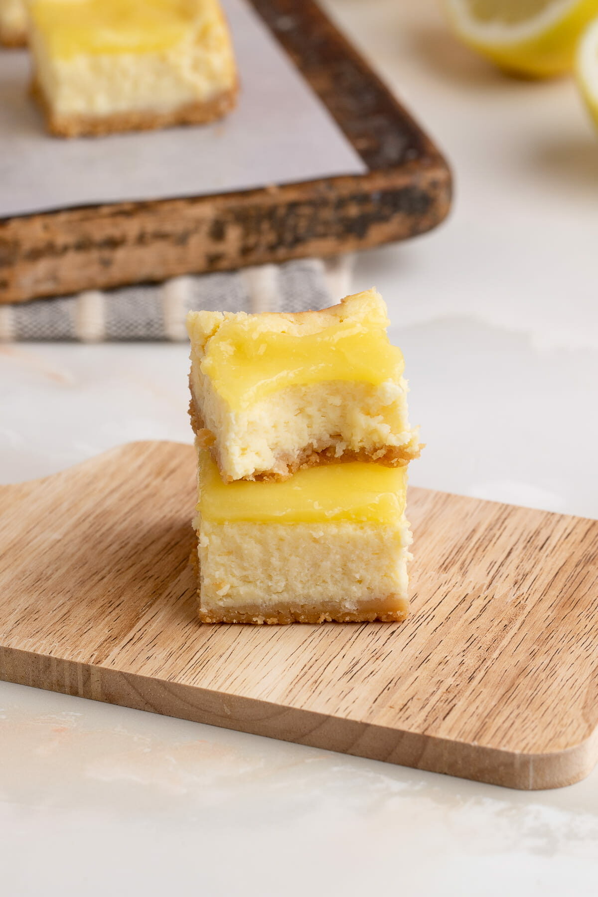 lemon cheesecake bars stacked with bite taken out.
