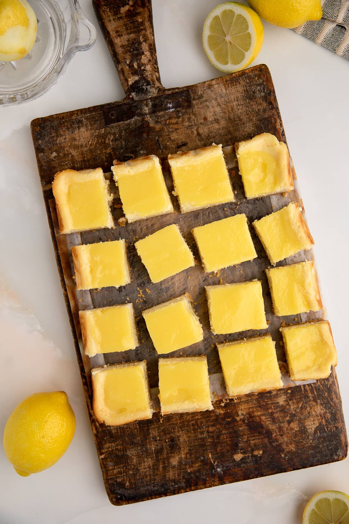 lemon cheesecake squares sliced on cutting board.