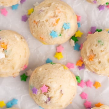 edible sugar cookie dough balls on parchment with sprinkles.