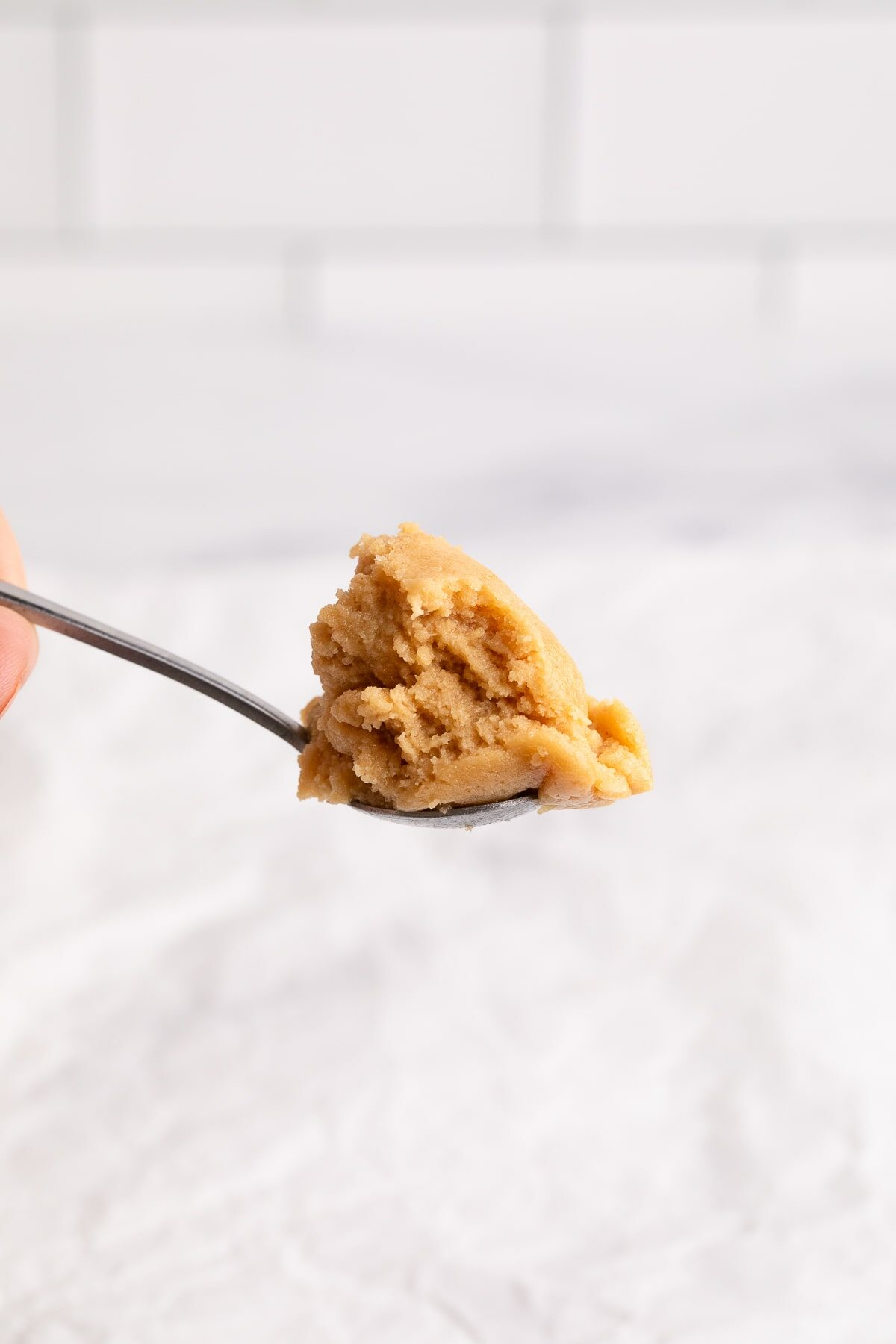 edible peanut butter cookie dough on spoon.