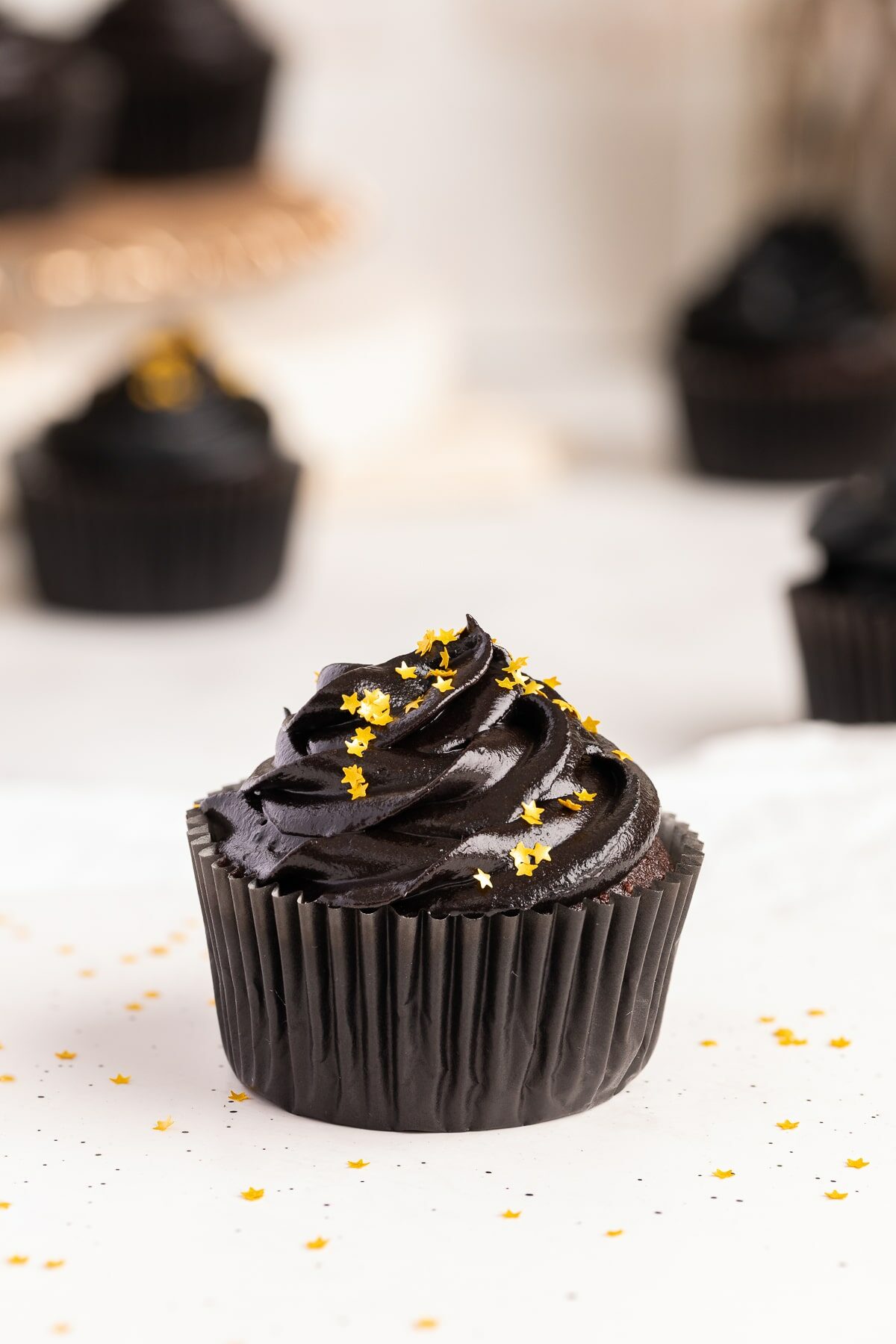 black frosting made with black cocoa powder on cupcake.