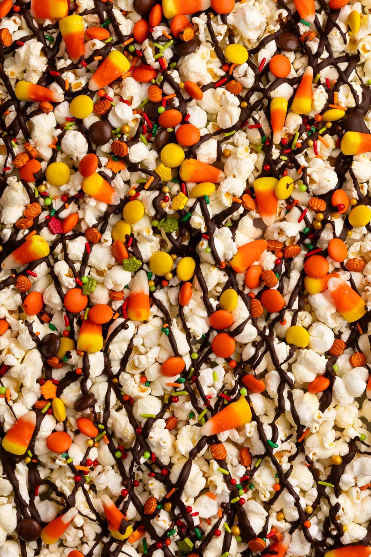 candy corn popcorn on baking sheet with toppings up close.