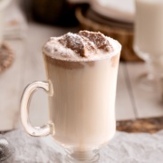 Warm Vanilla Milk with chocolate whipped cream and powdered sugar up close.