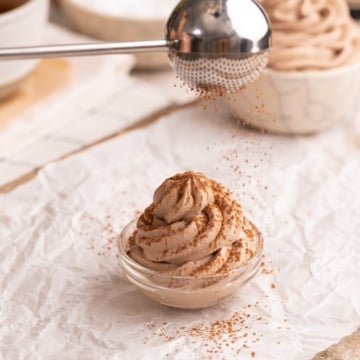 sprinkling cocoa powder on top of chocolate whipped cream.