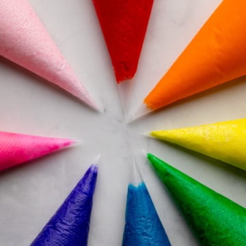 brightly colored frostings in piping bags.