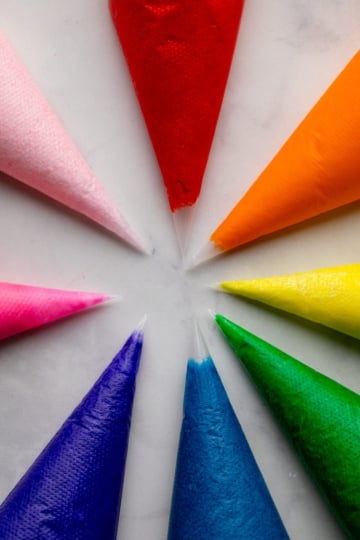 brightly colored frostings in piping bags.