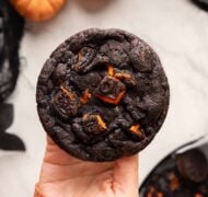 holding oreo halloween chocolate cookie.