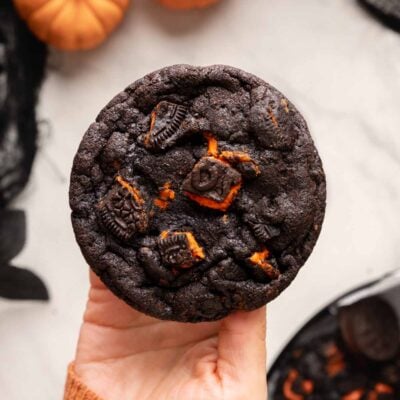 holding oreo halloween chocolate cookie.