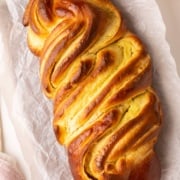 baked challah on cutting board.