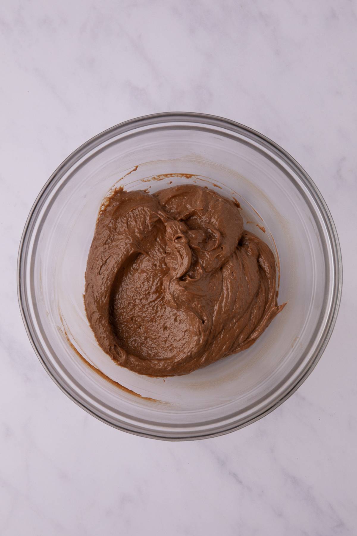 mixed cream cheese and Nuttela in a glass bowl on a grey counter.