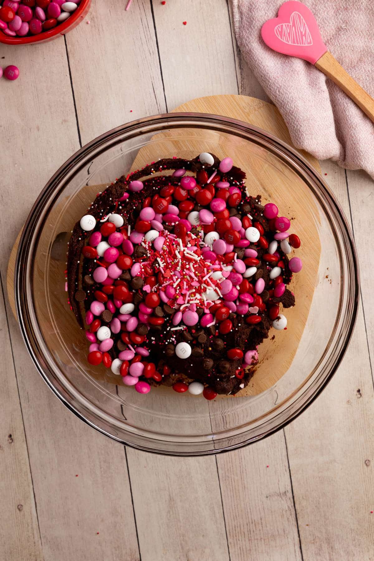 Spinkles, chocolate chips, M&Ms on top of the chocolate cookie dough.