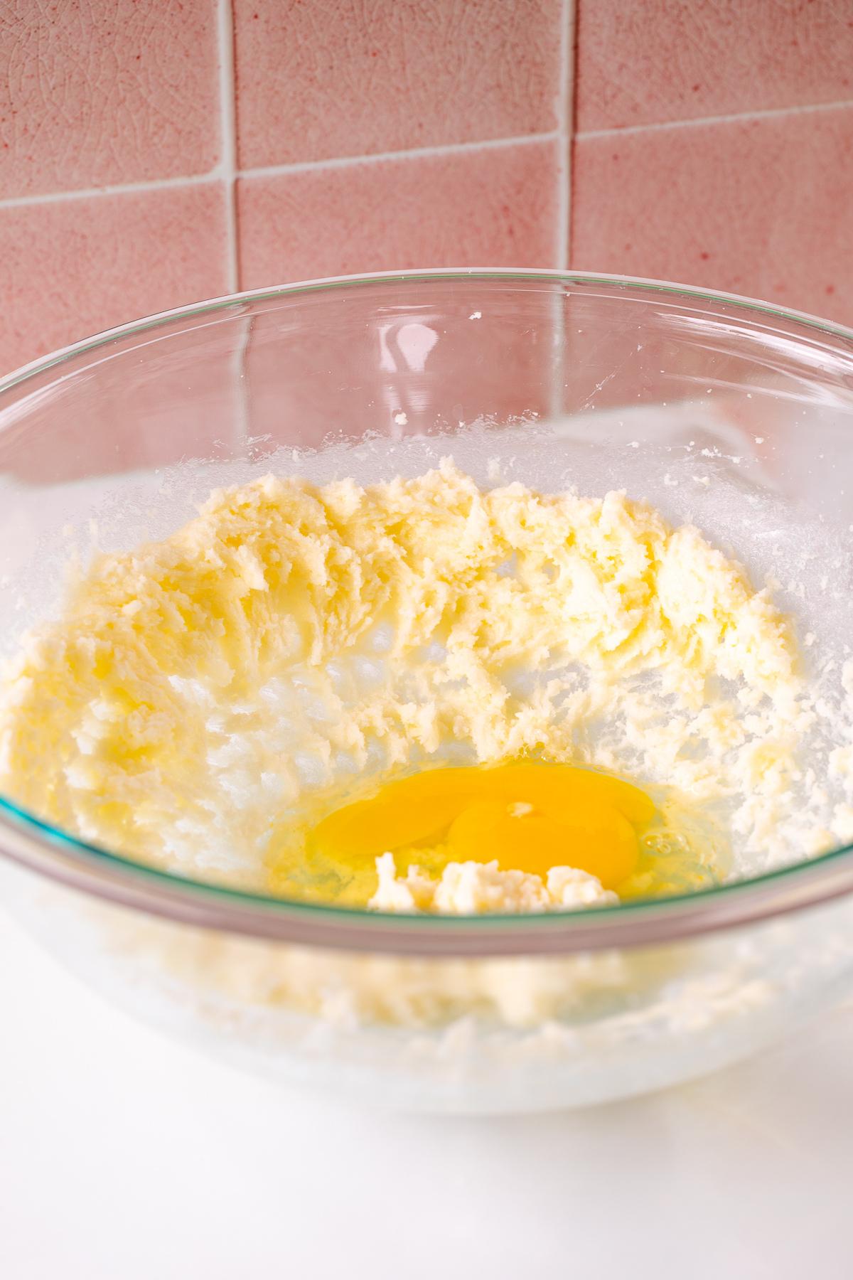 adding an egg to creamed butter and sugar for tartlets.