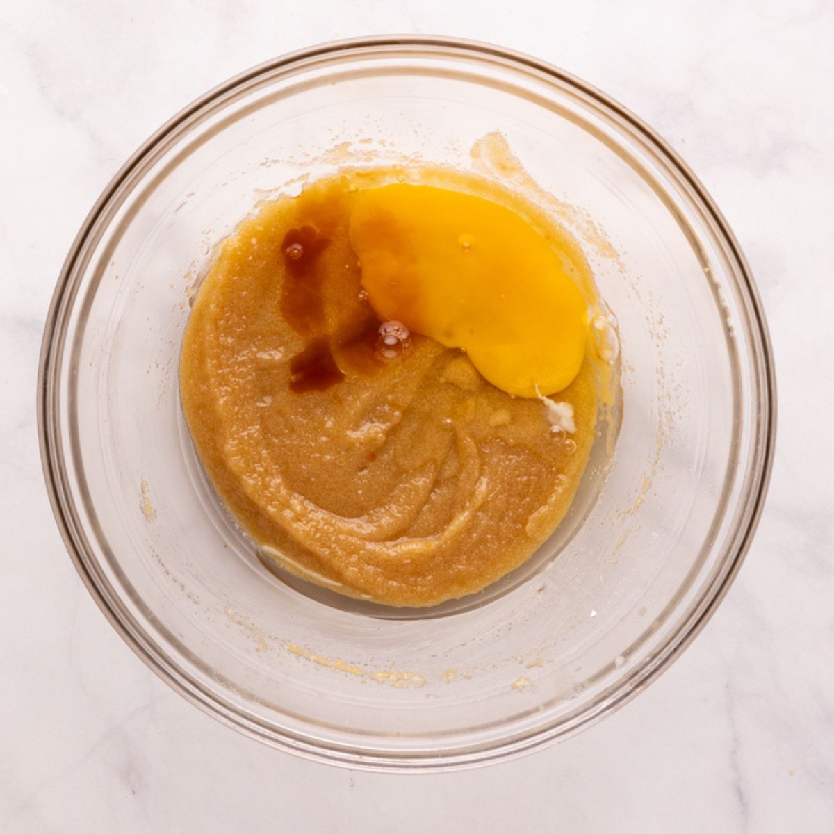 adding wet ingredients to the sugar and melted butter.