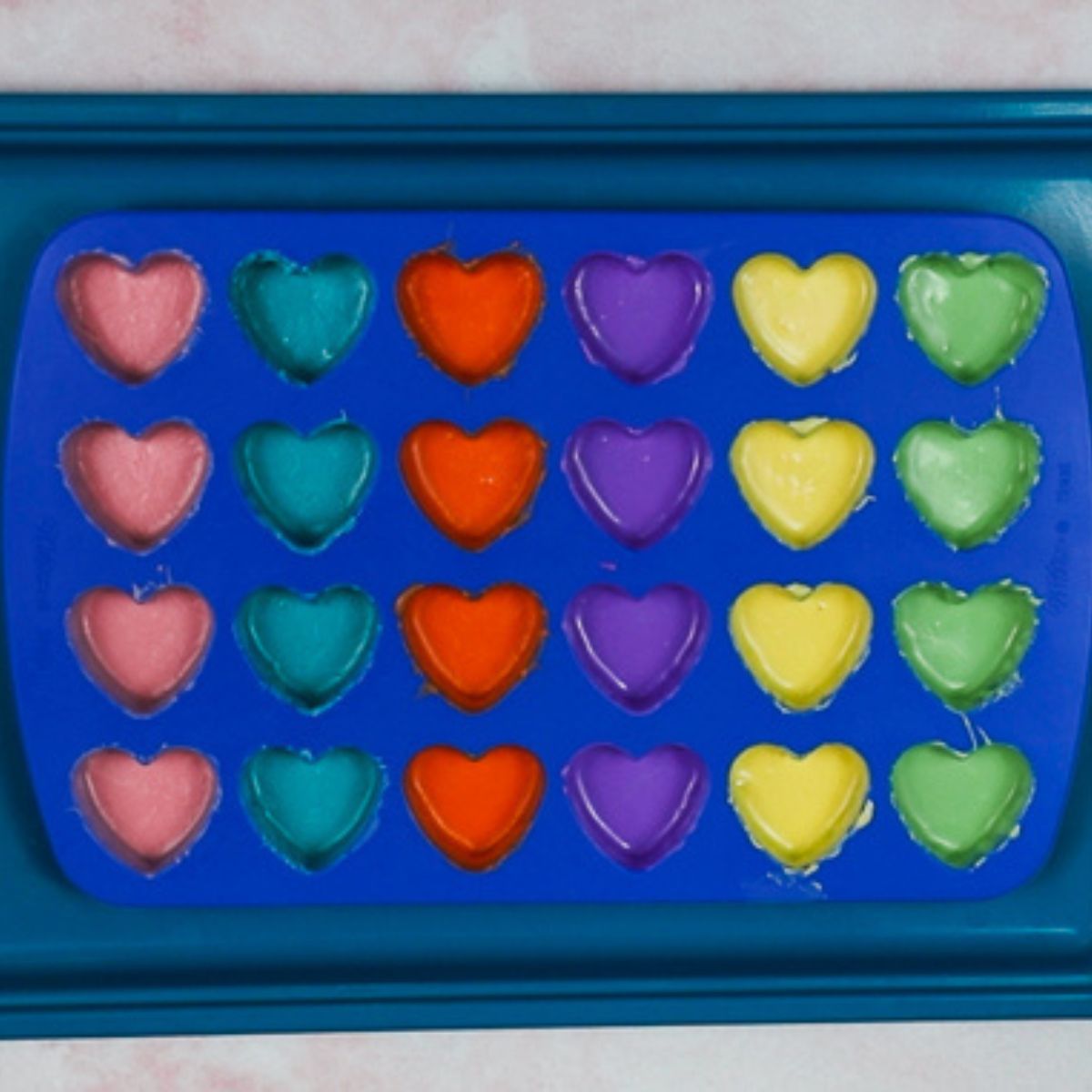 heart shaped silicone mold with multi colors of chocolate into the molds.
