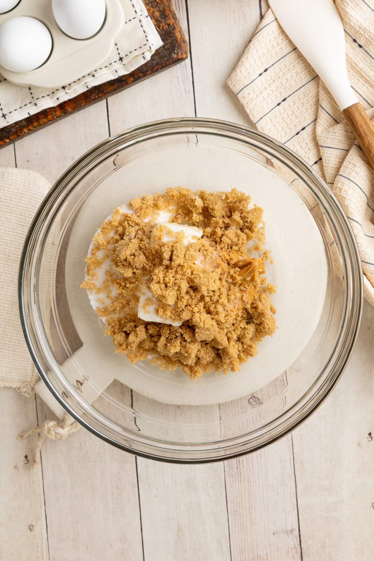 butter and sugars in glass bowl, unmixed.